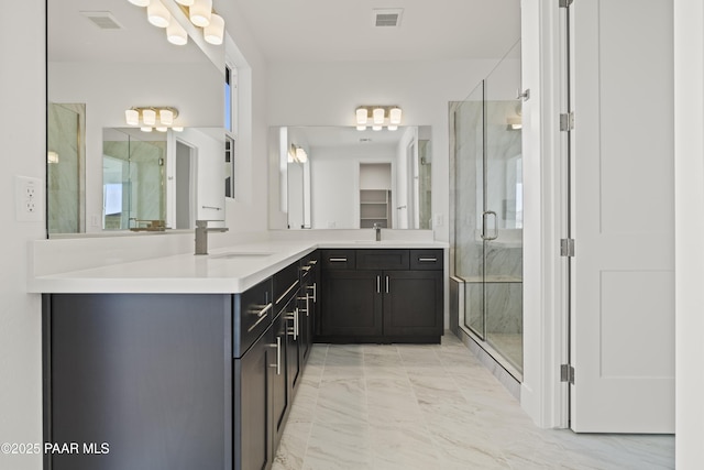 bathroom with vanity and a shower with shower door