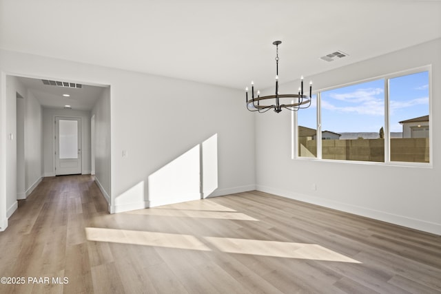 unfurnished dining area featuring light hardwood / wood-style flooring and a notable chandelier