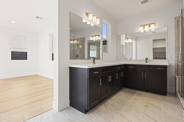 bathroom featuring vanity, a shower with shower door, and an inviting chandelier