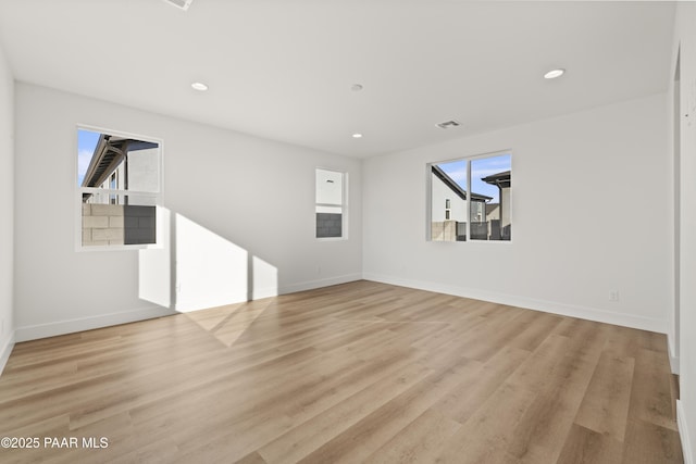 unfurnished living room featuring plenty of natural light and light wood-type flooring