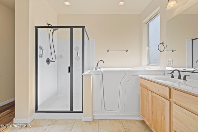 bathroom featuring tile patterned flooring, vanity, and separate shower and tub