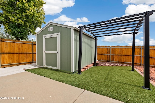 view of shed featuring a fenced backyard and a pergola