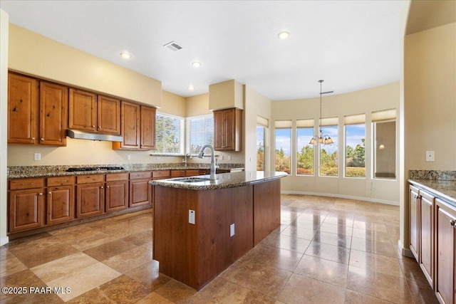 5560 W Halcyone Cir, Prescott, AZ 86305 - kitchen with under cabinet range hood, visible vents, brown cabinetry, and dark stone countertops