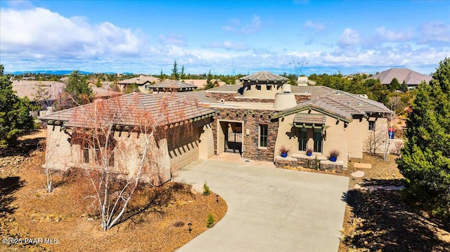 5560 W Halcyone Cir, Prescott, AZ 86305 - view of front facade featuring driveway, a garage, stone siding, a tiled roof, and stucco siding