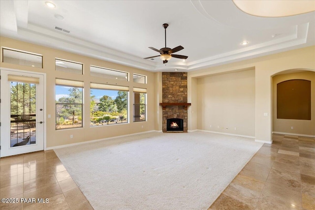 5560 W Halcyone Cir, Prescott, AZ 86305 - unfurnished living room featuring a wealth of natural light, a tray ceiling, a fireplace, and visible vents