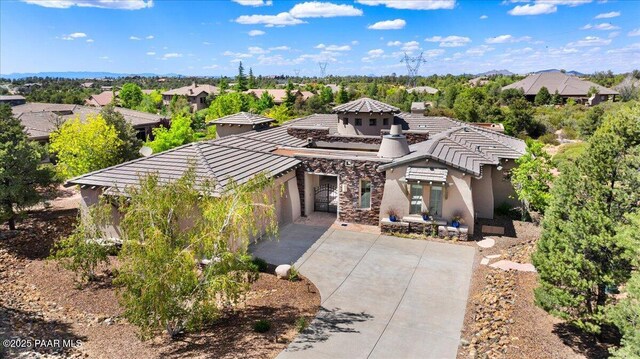 5560 W Halcyone Cir, Prescott, AZ 86305 - mediterranean / spanish house with stone siding, concrete driveway, a tiled roof, and stucco siding