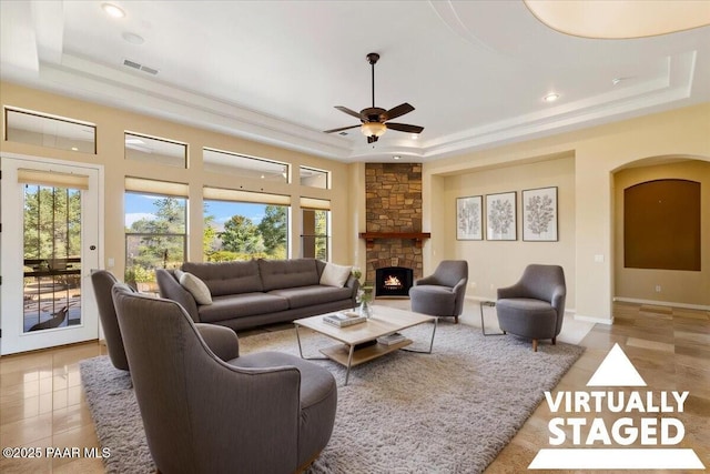 5560 W Halcyone Cir, Prescott, AZ 86305 - tiled living area with arched walkways, a fireplace, visible vents, baseboards, and a raised ceiling