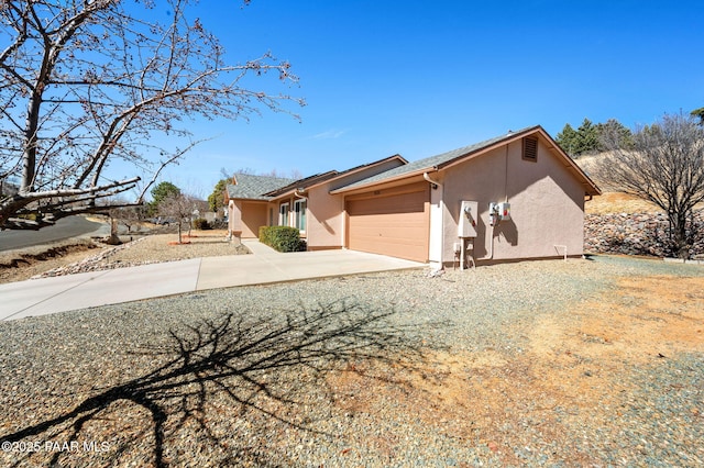 view of front of house featuring concrete driveway, an attached garage, and stucco siding