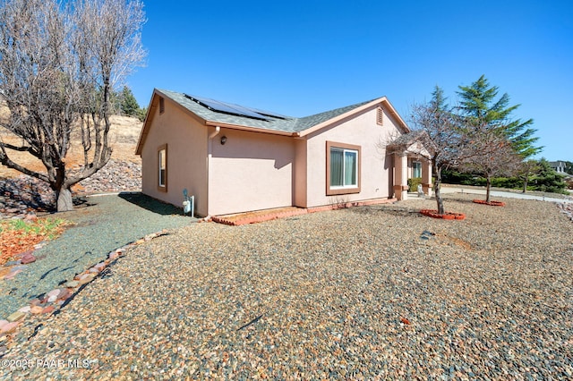 view of front of home featuring solar panels and stucco siding