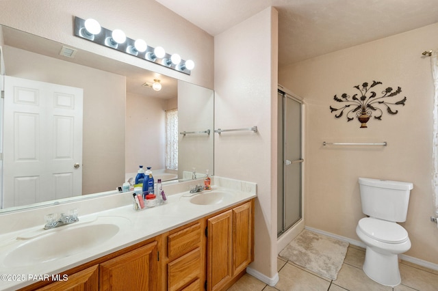 bathroom with a stall shower, a sink, toilet, and tile patterned floors