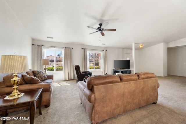 living area with a ceiling fan, visible vents, and light colored carpet