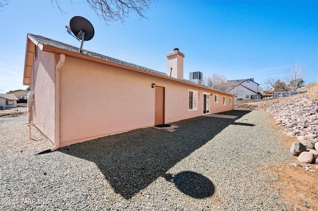 back of property featuring cooling unit, a patio area, and stucco siding