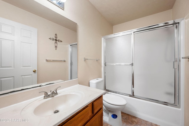 bathroom featuring combined bath / shower with glass door, vanity, and toilet