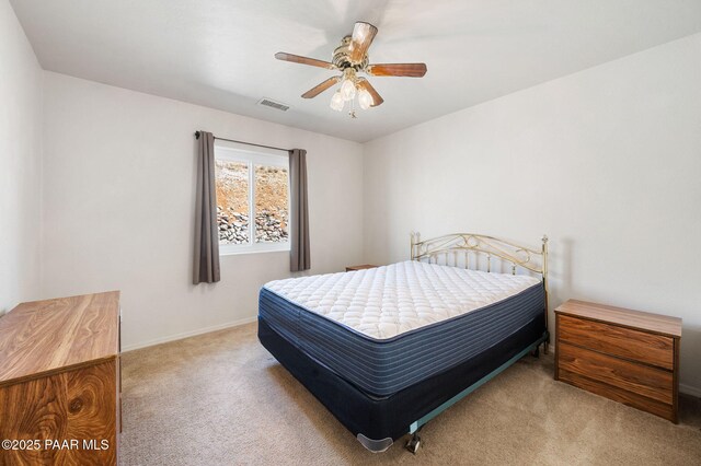 carpeted bedroom featuring visible vents and a ceiling fan