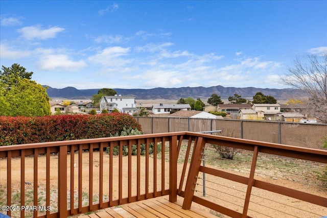 deck with a fenced backyard, a mountain view, and a residential view