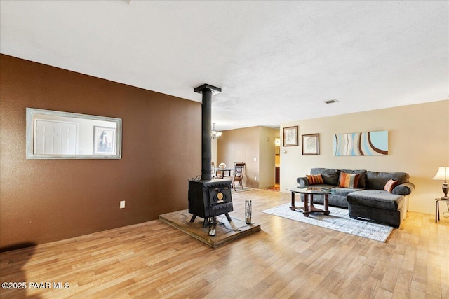 living room featuring light wood-type flooring and a wood stove