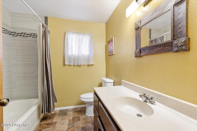 full bathroom with shower / bath combo, vanity, toilet, stone finish floor, and baseboards