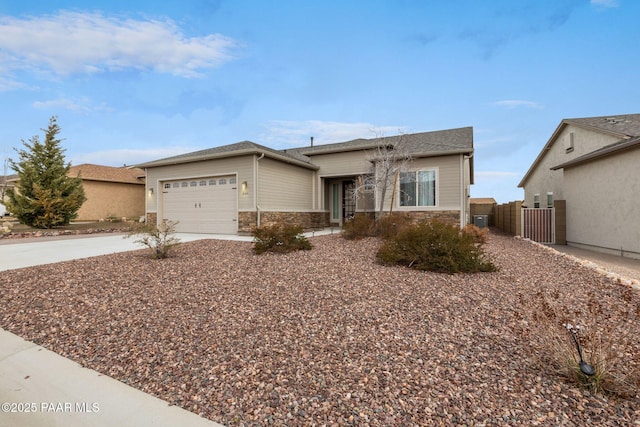 ranch-style house featuring fence, an attached garage, concrete driveway, stone siding, and central air condition unit