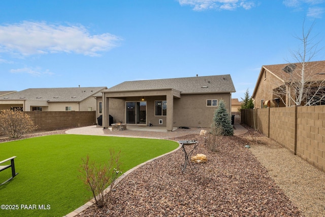 rear view of house with a patio area, a fenced backyard, a lawn, and stucco siding