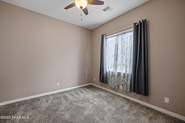 carpeted spare room featuring a ceiling fan, visible vents, and baseboards