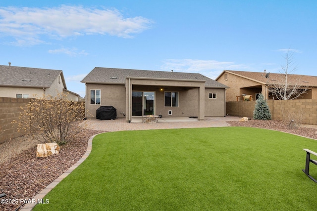 back of property featuring stucco siding, a yard, a fenced backyard, and a patio area