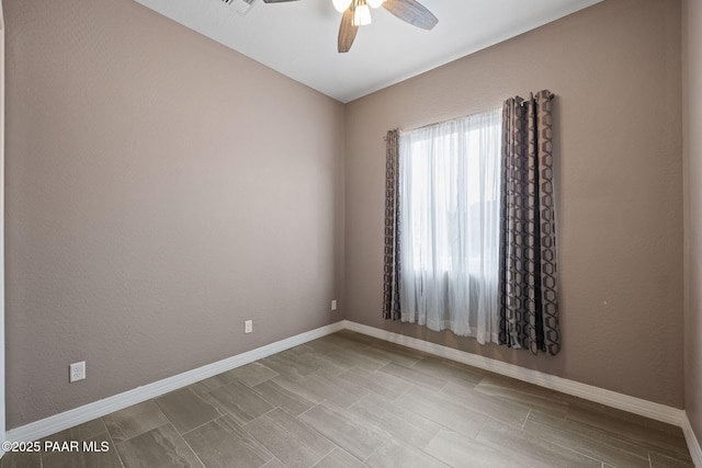 spare room featuring visible vents, baseboards, and a ceiling fan