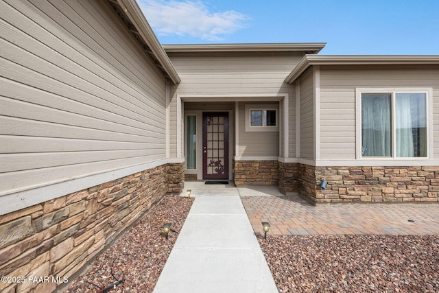 view of exterior entry featuring stone siding