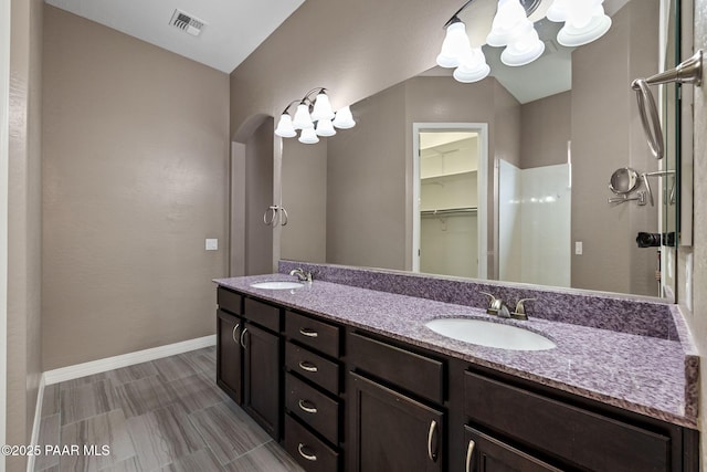 full bathroom featuring double vanity, baseboards, visible vents, and a sink