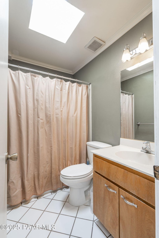 bathroom featuring toilet, crown molding, a skylight, vanity, and tile patterned flooring