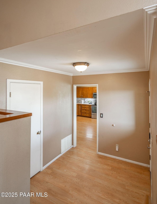 corridor featuring ornamental molding and light wood-type flooring