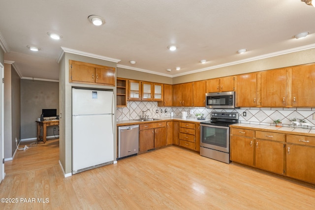 kitchen featuring sink, light hardwood / wood-style flooring, appliances with stainless steel finishes, ornamental molding, and decorative backsplash