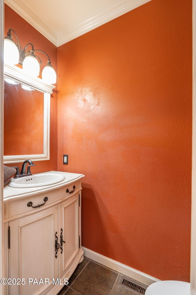 bathroom with tile patterned flooring, ornamental molding, and vanity