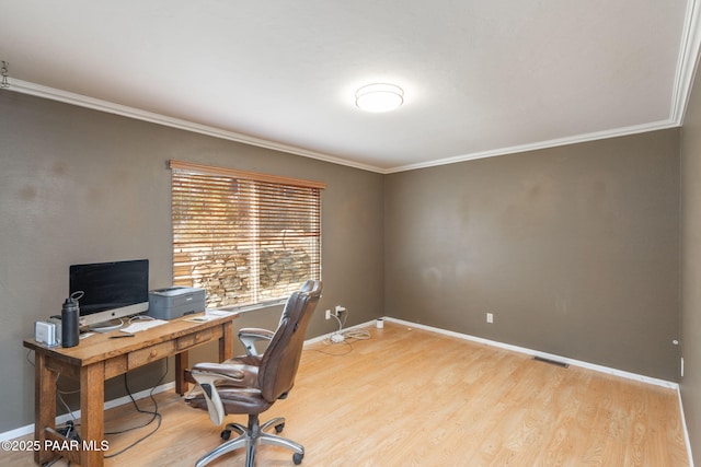 office space with ornamental molding and light hardwood / wood-style floors