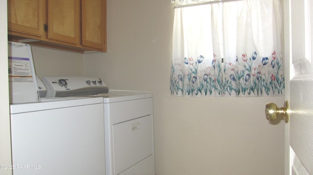 clothes washing area featuring cabinet space and washing machine and dryer