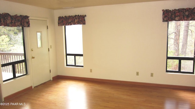 unfurnished room with light wood finished floors and baseboards