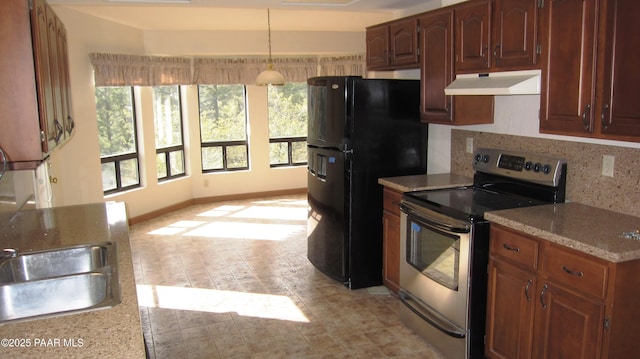 kitchen with under cabinet range hood, electric range, baseboards, backsplash, and freestanding refrigerator