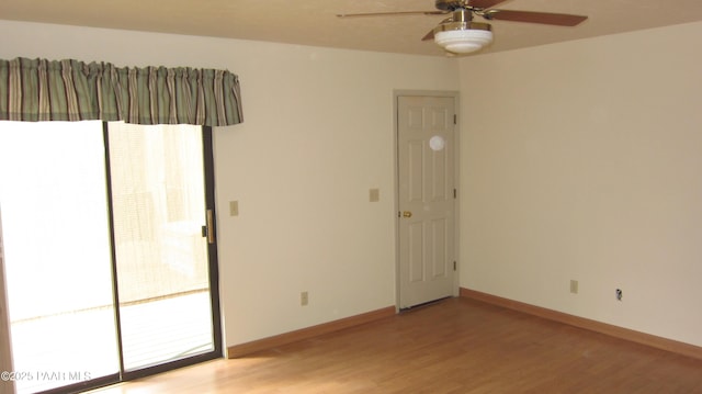 spare room featuring light wood-style flooring, baseboards, and a ceiling fan