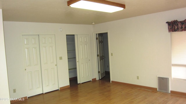 918 Marcus Dr, Prescott, AZ 86303 - unfurnished bedroom with wood finished floors, multiple closets, and baseboards