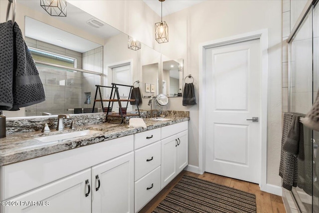 bathroom featuring vanity, wood-type flooring, and walk in shower