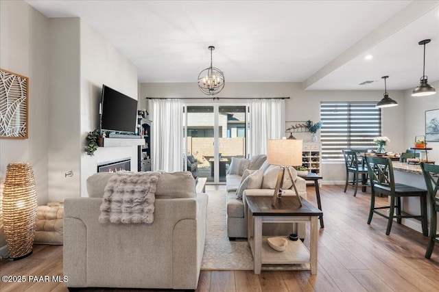 living room with a chandelier and light hardwood / wood-style floors