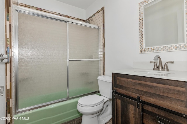 full bathroom with shower / bath combination with glass door, vanity, and toilet