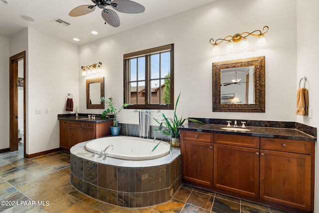 bathroom with vanity, toilet, ceiling fan, and tiled tub