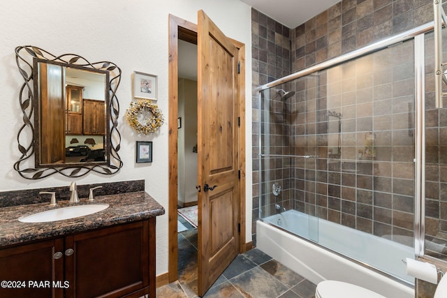 full bathroom with shower / bath combination with glass door, vanity, and toilet