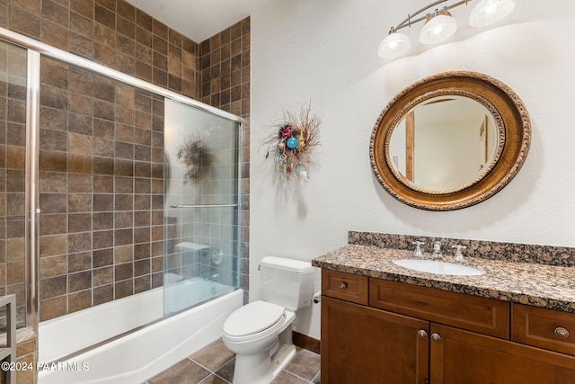 full bathroom featuring tile patterned floors, vanity, toilet, and bath / shower combo with glass door