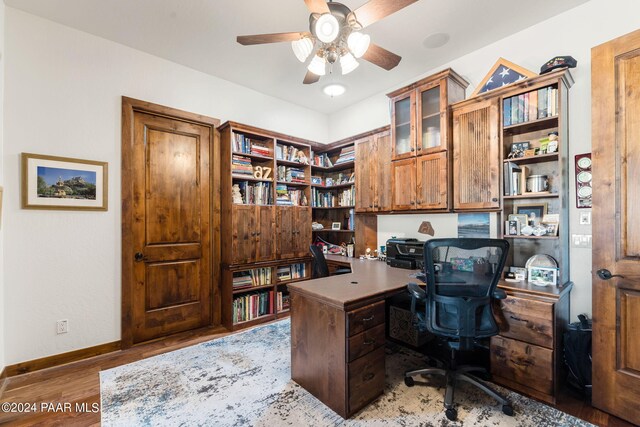 office area with ceiling fan, hardwood / wood-style floors, and built in desk