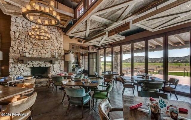 interior space featuring beamed ceiling, a notable chandelier, a mountain view, and a fireplace