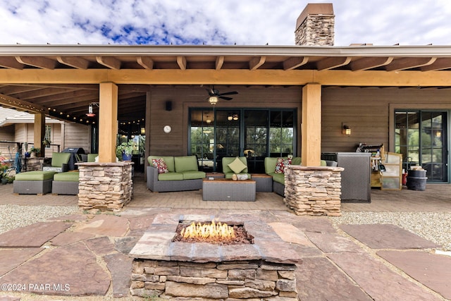 view of patio / terrace with an outdoor living space with a fire pit and ceiling fan