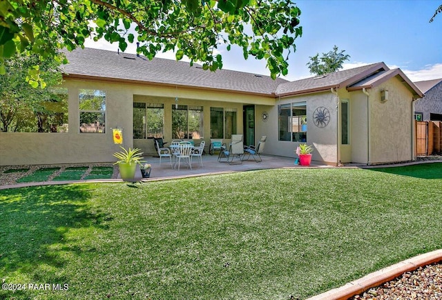 rear view of house featuring a patio and a lawn