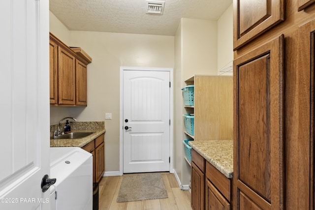 26455 N Bull Snake Rd, Paulden, AZ 86314 - laundry room featuring cabinet space, light wood-type flooring, a textured ceiling, and washing machine and clothes dryer