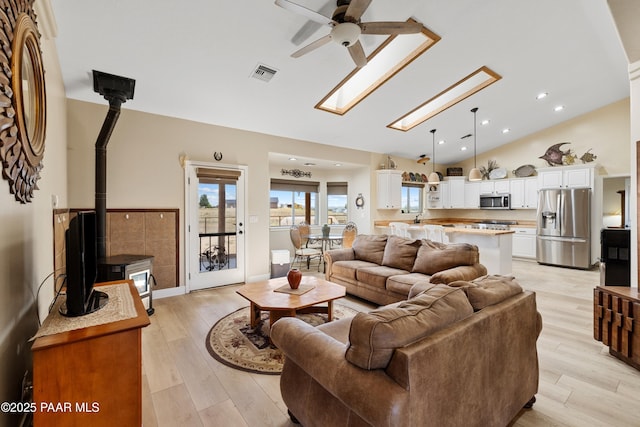 26455 N Bull Snake Rd, Paulden, AZ 86314 - living area with vaulted ceiling, ceiling fan, a wood stove, light wood-style floors, and recessed lighting